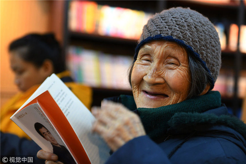 呼伦贝尔,在牙克石新华书店,一位在阅读的84岁老人绽放灿烂的笑容