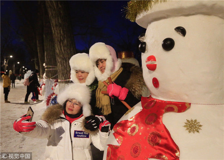 松花江冰雪嘉年华中2019个雪人,今天开始穿衣服,工作人员给他们戴上