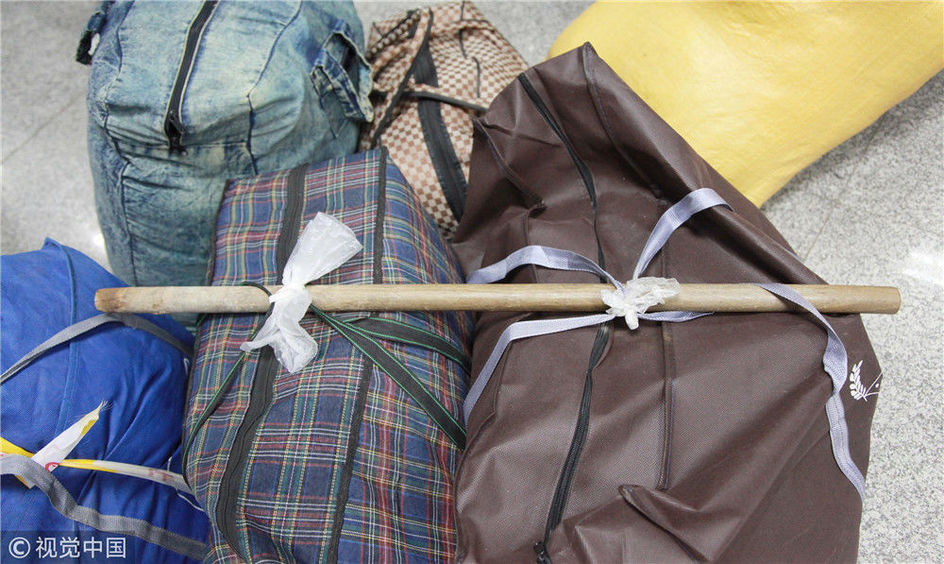 春运"神器":棍子式的扁担,可以挑起重件行李物品.