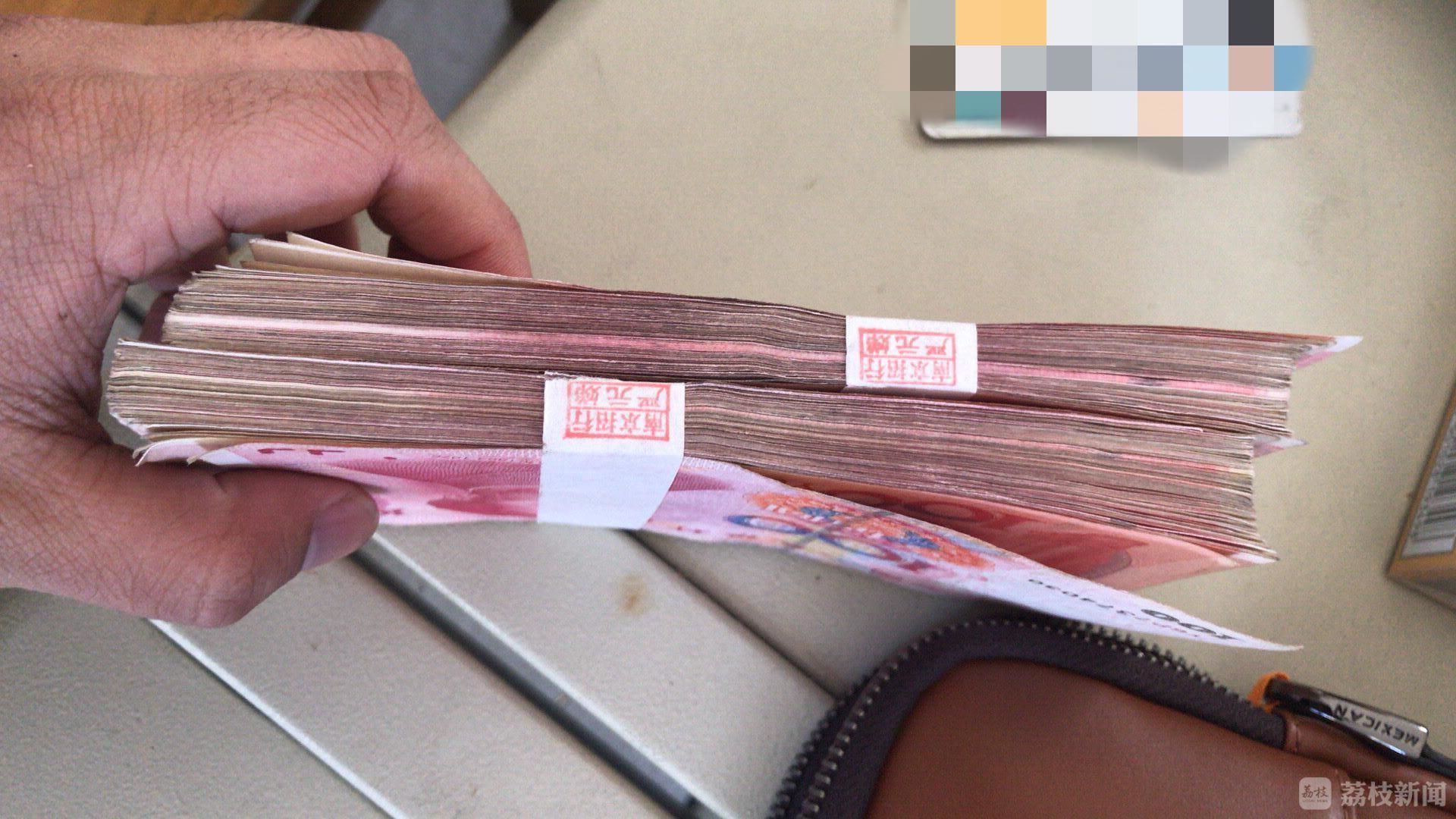 家住南京和熙臻苑的陈女士在自家楼下发现了两搭套着封条的人民币