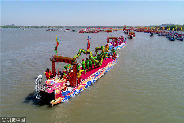 2018年4月8日,江苏泰州,在溱潼会船节上,当地农民在龙舟上舞龙.