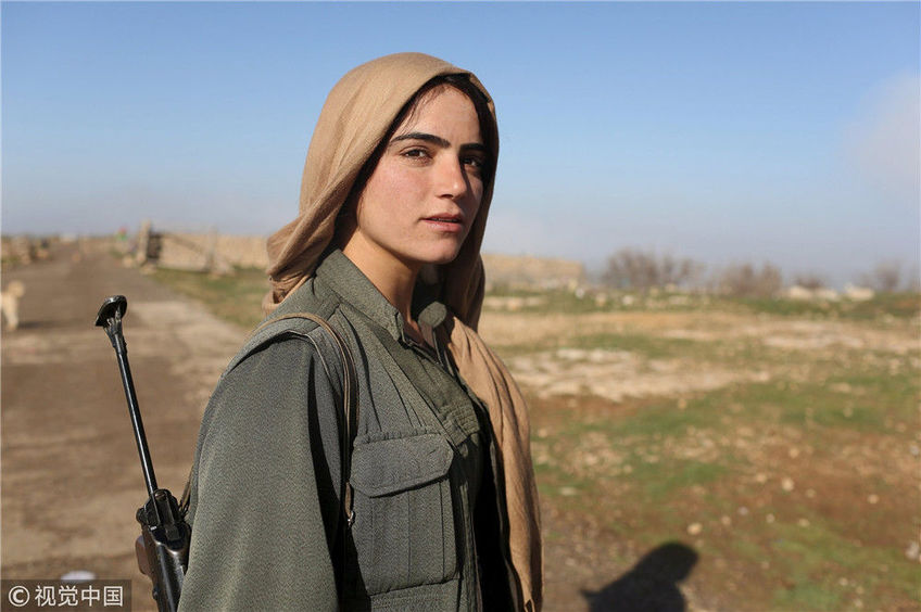当地时间2015年3月13日,伊拉克辛贾尔山区,一名库尔德女兵站在一个