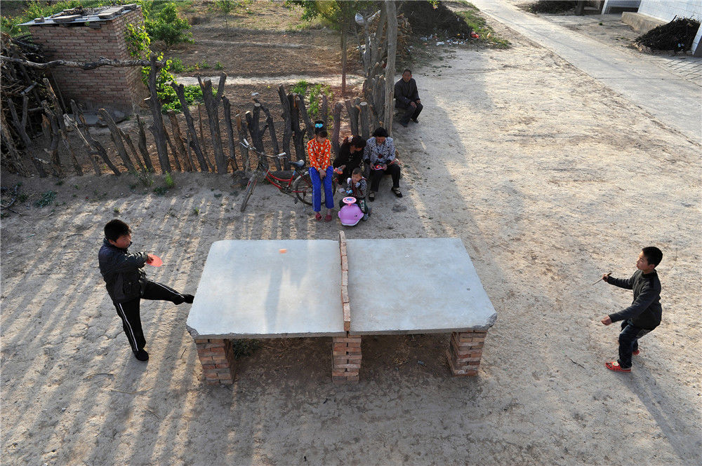 2013年4月13日,山西芮城,两名小朋友在村里一个水泥板搭成的乒乓球台