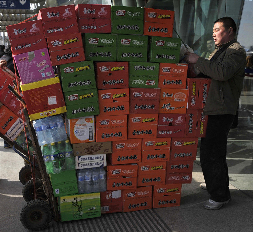 南京火车站广场上商场工人在搬运康师傅,福满多方便面食品和饮料