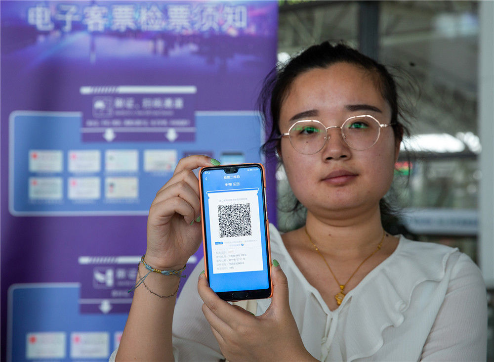 在南京火车站候车厅,一名旅客展示12306客户端生成的检票二维码