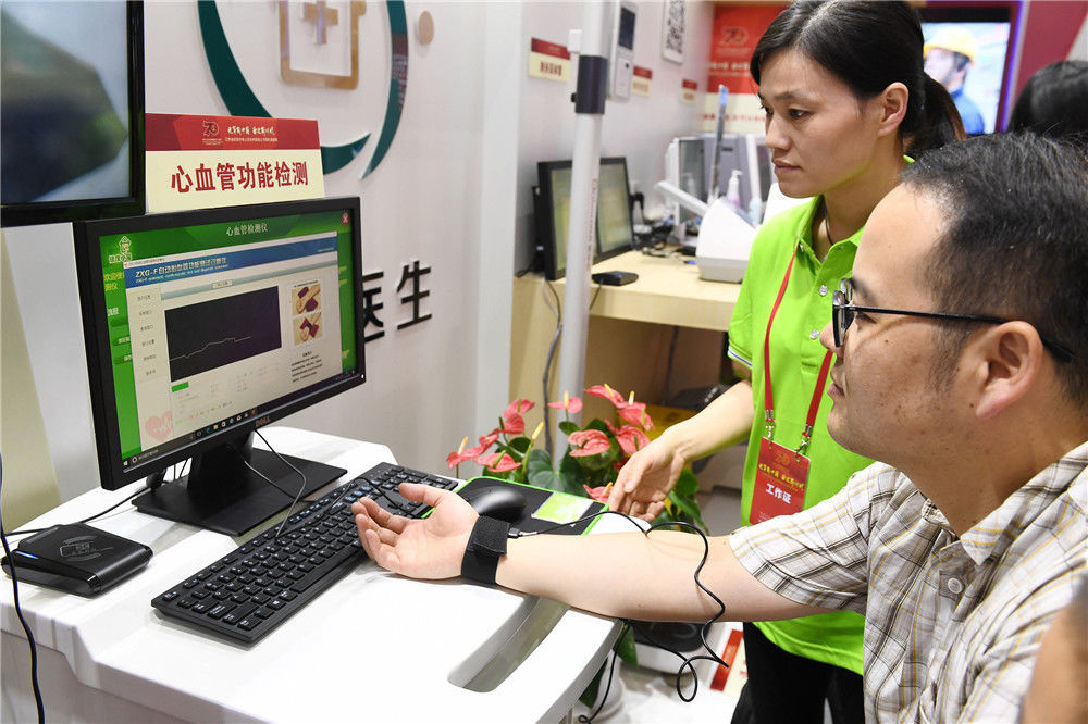 一名参观者在江苏省庆祝新中国成立70周年成就展上现场体验保健服务