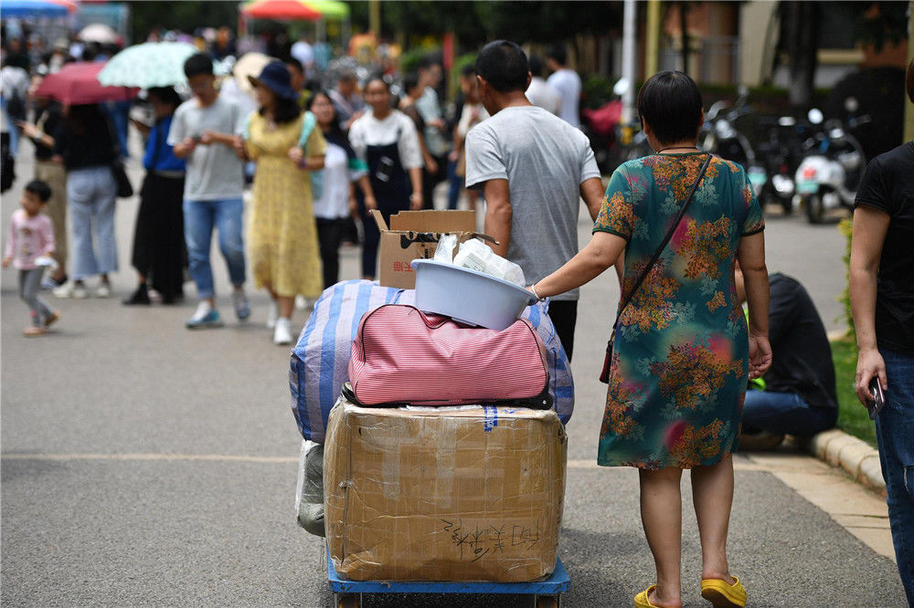 当日,位于昆明的云南大学迎来开学季,众多就读该校的大一新生在父母和