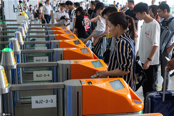 2019年7月27日,在南京火车站候车厅,旅客通过检票闸机进站