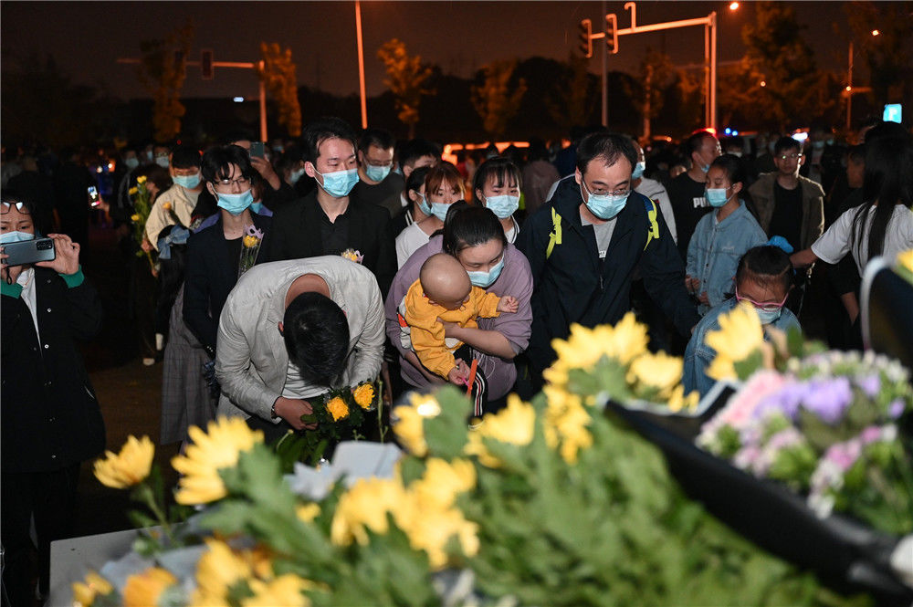 2021年5月22日晚,长沙明阳山殡仪馆门前,市民群众排队给袁隆平献花.
