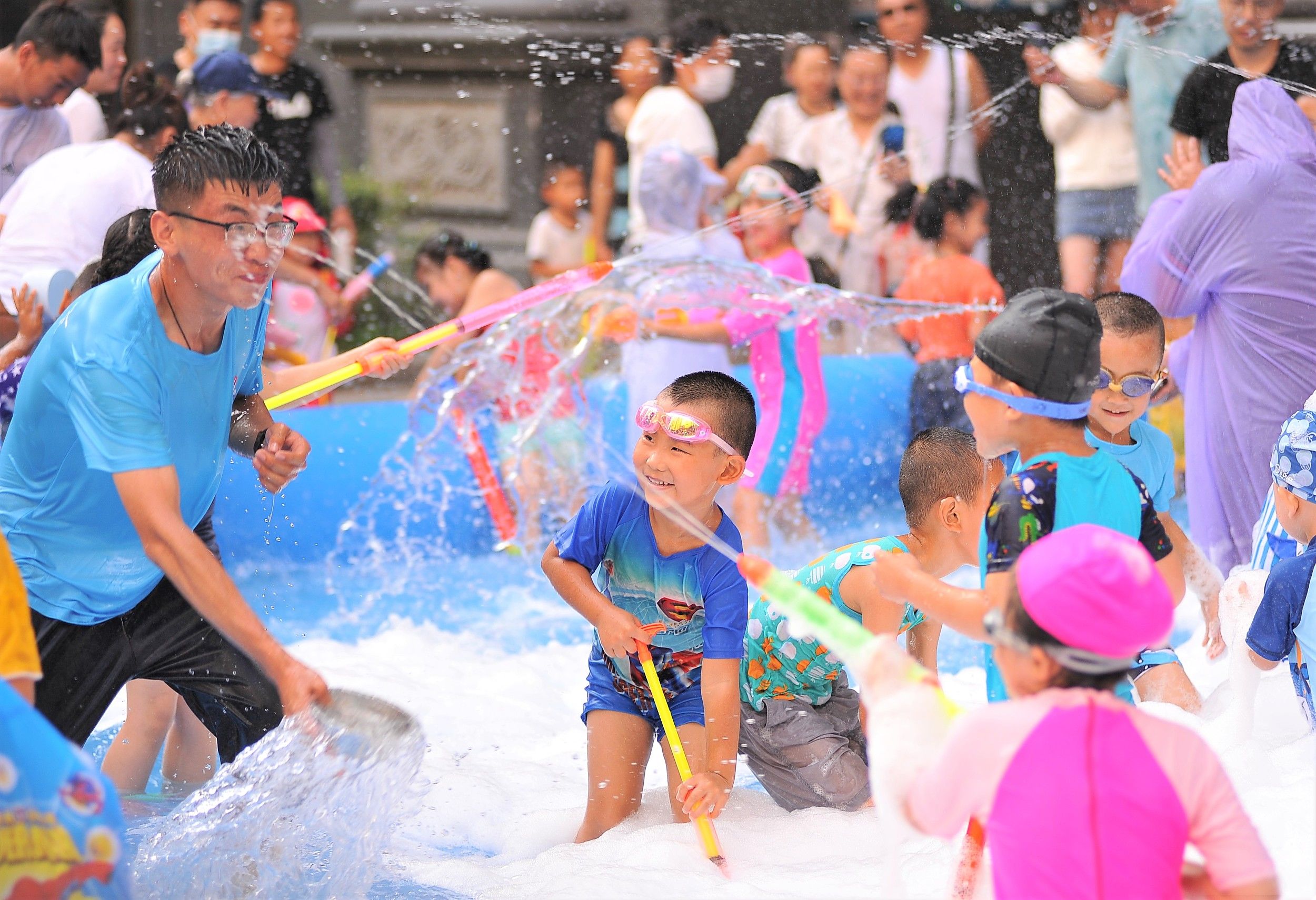 7月24日哈尔滨气温高达34,孩子们纷纷到嬉水池中享受清凉