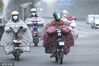 2022年11月28日，江苏连云港，赣榆区街头的市民“全副武装”骑车出行。
