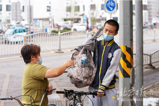  家长送学生上学。
