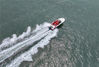 2022年6月18日，在江苏省连云港连岛大沙湾游乐场，一艘载有游客的快艇在海面上驰过。