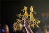 2020年8月25日，河南省汤阴县民间艺人苏小年在夜经济晚会上展示自己现场制作的七夕糖画作品《牛郎织女鹊桥相会》。通过创作糖画作品的形式，祝愿天下有情人家庭幸福美满。/IC photo
