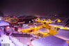 2023年1月18日，哈尔滨，雪乡风景区灯光璀璨，积雪如棉被覆盖建筑。