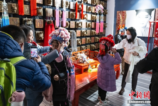 图为小朋友们在家长的“指挥”帮助下体验部分京剧服饰。 中新社记者 侯宇 摄