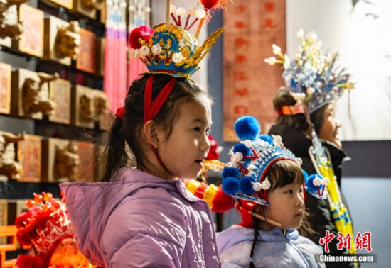 图为小朋友们体验部分京剧服饰。 中新社记者 侯宇 摄