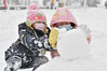 2023年1月24日，小朋友在山东省烟台市福山区河滨广场堆雪人。
