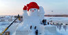 2023年12月3日，哈尔滨市，友谊西路的松花江畔，今冬的第一座大雪人即将完工。他高约20米，戴着红色的丝绒帽子，有着大大的胡萝卜鼻子，大大的圆眼睛满含笑意，温暖着冬日的寒。
