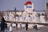 2023年12月3日-12月4日，哈尔滨市，友谊西路的松花江畔，今冬的第一座大雪人即将完工。他高约20米，戴着红色的丝绒帽子，有着大大的胡萝卜鼻子，大大的圆眼睛满含笑意，温暖着冬日的寒。签约供稿人/视觉中国 编辑/康娜 