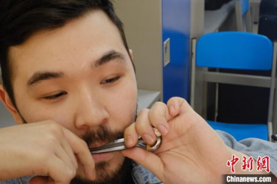 图为一名俄罗斯留学生正在吹奏一种俄罗斯乐器，他将这种乐器随身携带。　李娇阳 摄