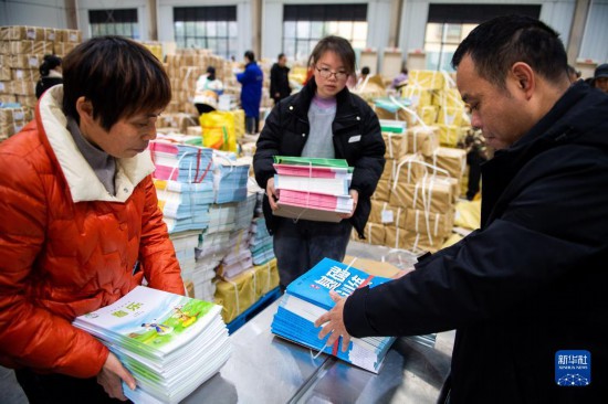 2月4日，在祁阳市新华书店教材中转库，工作人员在打捆教材。