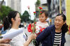 2023年5月12日，贵州省仁怀市文化广场，工作人员为路过的母亲送上鲜花。