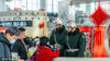2024年2月9日，南京，高铁站内执勤的警备军人为返乡旅客答疑解惑。