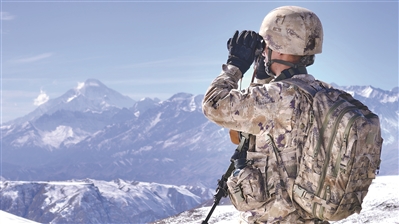 昆木加哨所，战士在雪山上瞭望。